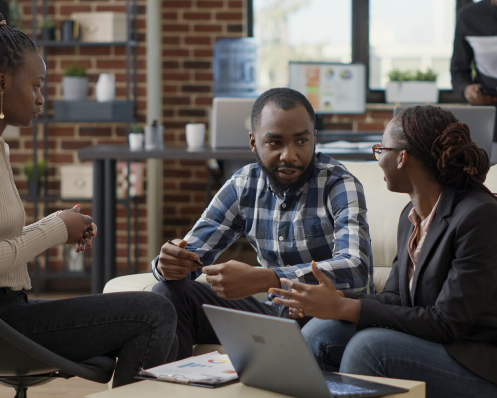 Team of business people collaborating to plan financial strategy, doing teamwork to create sales report on laptop. Office employees working on project strategy to analyze career growth.