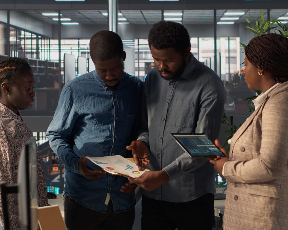 black-leader-reviews-company-strategy-with-her-team-members-corporate-office (1)