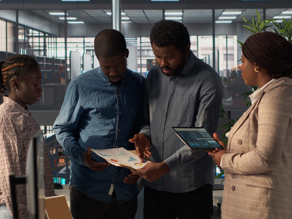 black-leader-reviews-company-strategy-with-her-team-members-corporate-office (1)